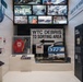 This image shows a museum exhibition dedicated to the September 11, 2001 attacks and recovery efforts, specifically focused on USACE (U.S. Army Corps of Engineers) operations at the Pentagon and World Trade Center. The display features authentic artifacts, signage, and multimedia screens documenting rescue, recovery, and forensic operations. The exhibit is professionally curated with labeled display cases, informational panels, and archival photographs.