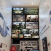 This image shows a museum exhibit dedicated to the September 11, 2001 attacks and their aftermath, focusing on recovery and response efforts. The display features a prominent 'WTC DEBRIS TO SORTING AREA' directional sign, physical artifacts in glass cases, and a large video wall showing multiple photographs of Ground Zero, the Pentagon, and recovery operations. The exhibit appears to be part of a U.S. Army Corps of Engineers (USACE) installation titled 'USACE at the Pentagon: Building for Resilience.'