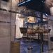 A museum exhibit dedicated to Nuclear Power, featuring a scale model of what appears to be the Army's MH-1A Sturgis floating nuclear power plant ship displayed in a glass case. The exhibit includes informational panels describing the Army Corps of Engineers' role in managing the world's first successful atomic energy program and the Manhattan Project. The display is part of a larger military history museum with additional exhibits visible in the background.