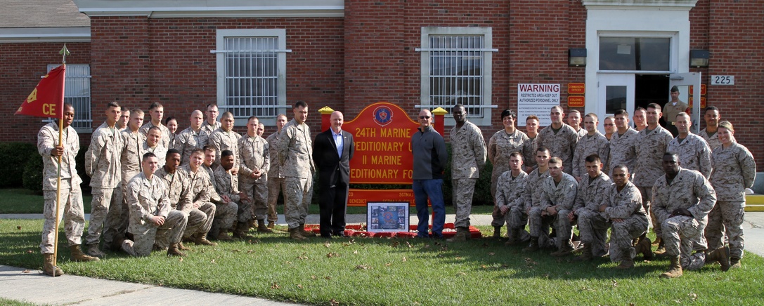 Marines and Sailors of the 24th Marine Expeditionary Unit pose for a photo with Beirut bombing survivors, Tony Sutton and John Dalziel, outside of the 24th MEU command building aboard Camp Lejeune, N.C., Oct. 23, 2013. The 24th MEU ran in honor of the Marines, Sailors and soldiers who lost their lives during the bombing 30 years ago.