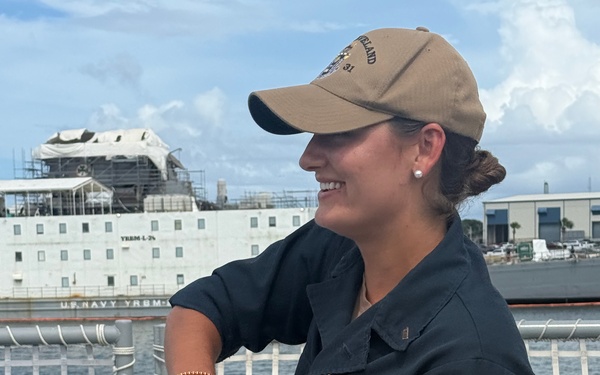 LTJG Anna Freyman retrieves her SWO pin from saltwater marking her an experienced and time tested Surface Warfare Officer