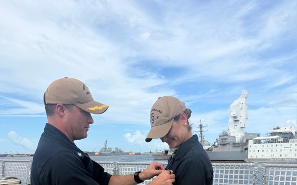 CDR Bruce Hallett pins LTJG Anna Freyman as a designated Surface Warfare Officer.