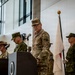 A formal military ceremony featuring personnel from multiple nations, including U.S. Army and what appears to be Japanese Ground Self-Defense Force soldiers. A senior U.S. Army officer wearing three-star rank insignia stands at a podium, suggesting a high-level command event such as a change of command or bilateral military exercise ceremony. Flags including the U.S. flag and Japanese flag are visible, held by honor guard soldiers.