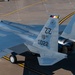 An aerial view of a U.S. Air Force F-15 Eagle fighter jet parked on a concrete flight line apron. The aircraft bears tail code 'ZZ' indicating assignment to the 18th Wing at Kadena Air Base, Japan, with serial number AF 22-022. The image is taken from an elevated angle, likely from a tower or elevated structure, showing the aircraft's upper fuselage, twin tail fins, and dual engine exhausts.