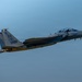 A U.S. Air Force F-15 Eagle fighter jet is captured in flight against a clear blue-gray sky. The aircraft bears tail code 'ZZ' indicating assignment to the 18th Wing at Kadena Air Base, Japan, with serial markings 'AF 22-022'. The aircraft appears to be carrying external ordnance or fuel tanks and is photographed in low-light conditions, likely at dusk or dawn.
