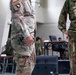 The image shows military personnel from at least two different nations standing in what appears to be a command or operations center. A U.S. Army soldier wearing OCP (Operational Camouflage Pattern) with a 101st Airborne Division patch and American flag is visible alongside personnel in a different camouflage pattern consistent with Japan Ground Self-Defense Force (JGSDF) uniforms. The setting suggests a joint military exercise or coordination meeting.