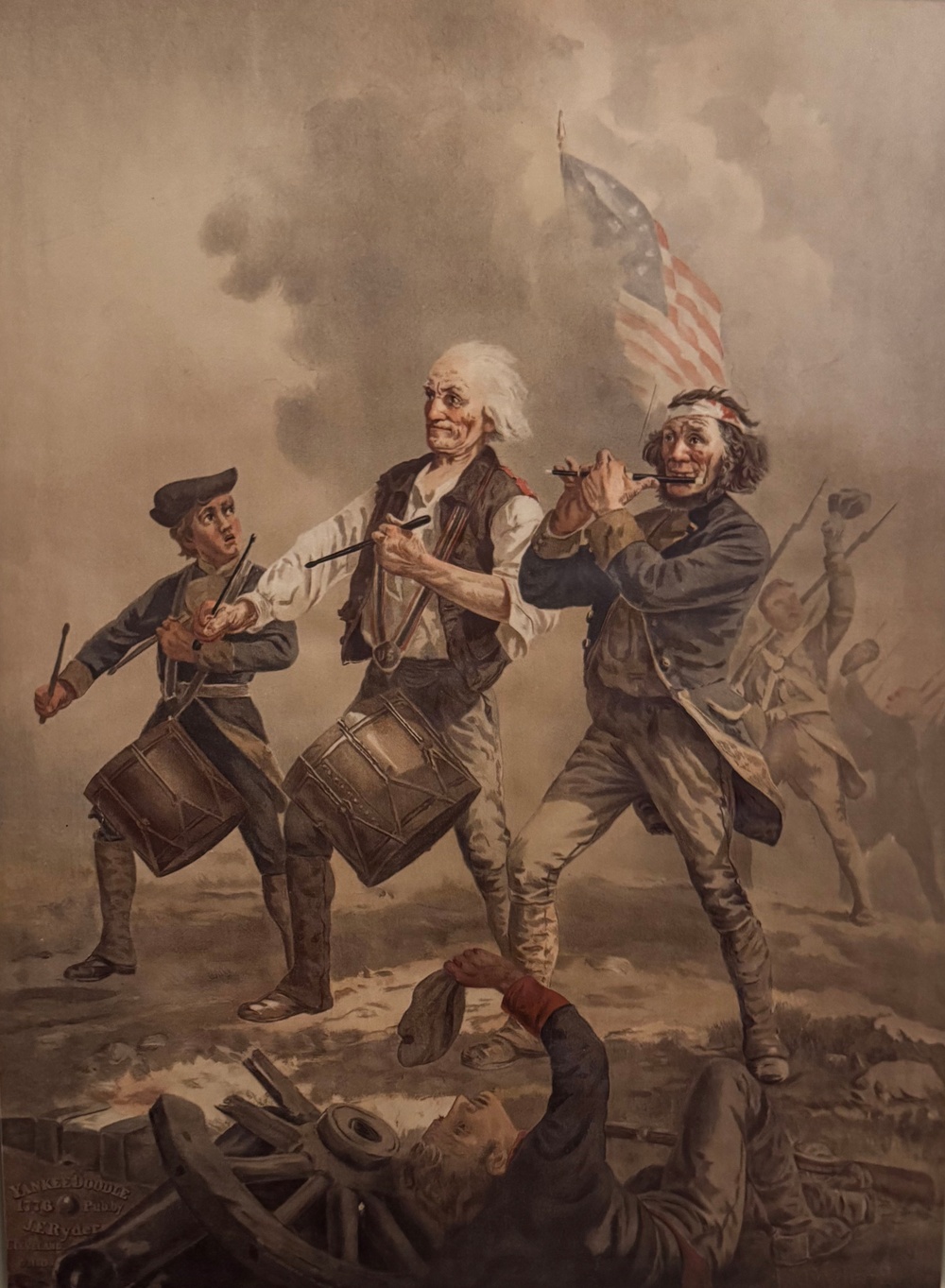 This is a reproduction or photograph of a patriotic American painting titled 'Yankee Doodle 1776' by J. Ryder, as indicated by the inscription in the lower left corner. The painting depicts three Revolutionary War-era musicians — a boy drummer, an elderly drummer, and a wounded fife player — marching forward amid battle smoke with an early American flag visible in the background. The composition is reminiscent of Archibald Willard's famous 'Spirit of '76' painting.