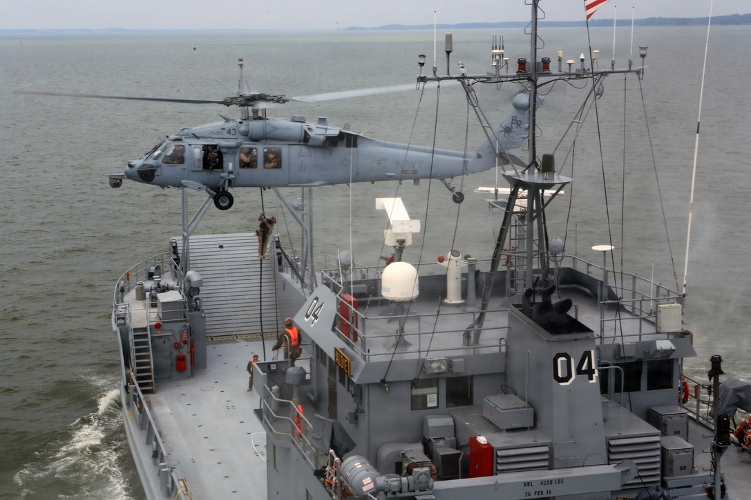 A Navy MH-60 Seahawk attached to the 8th Amphibious Squadron, hovers as the 24th Marine Expeditionary Unit’s Maritime Raid Force, Force Reconnaissance Company, 2nd Reconnaissance Battalion, fast rope onto a simulated vessel of interest during a Visit, Board, Search, and Seizure exercise at Joint Base Langley-Eustis, Va., July 15, 2014. VBSS operations are primarily conducted by the Maritime Raid Force for the purpose of Maritime Interdiction Operations.  The exercise is part of Realistic Urban Training and is the first major pre-deployment training exercise for the 24th MEU in preparation for their deployment later this year. (U.S. Marine Corps photo by Cpl. Devin Nichols)


