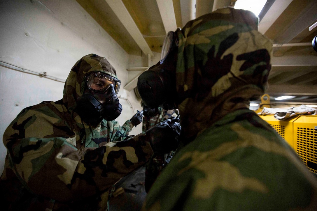 Corporal Jack Mcafee, left, a chemical, biological, radioactive, and nuclear defense specialist with Combat Logistics Battalion 24, 24th Marine Expeditionary Unit, ensures his fellow Marine has properly sealed his Mission Oriented Protective Posture suit aboard the amphibious transport dock USS New York, Jan. 13, 2015. The 24th MEU is embarked on the ships of the Iwo Jima Amphibious Ready Group and deployed to maintain regional security in the U.S. 5th Fleet area of operations. (U.S. Marine Corps photo by Cpl. Todd F. Michalek)