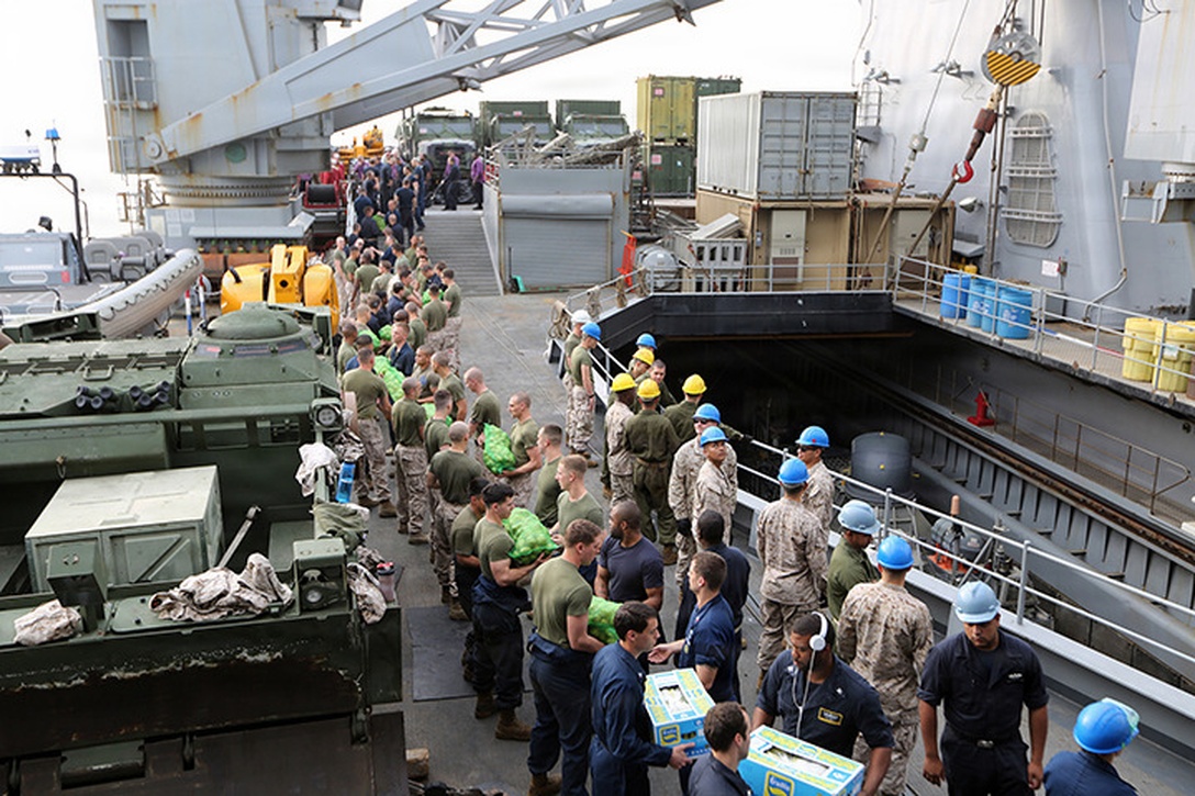 Marines with the 24th Marine Expeditionary Unit, and Sailors with the Iwo Jima Amphibious Ready Group, move supplies from the flight deck during a “resupply at sea,” or RAS, aboard the amphibious dock landing ship USS Fort McHenry, March 31, 2015. The 24th MEU is embarked on the ships of the Iwo Jima Amphibious Ready Group and deployed to maintain regional security in the U.S. 5th Fleet area of operations.  (U.S. Marine Corps photo by Sgt. Devin Nichols)