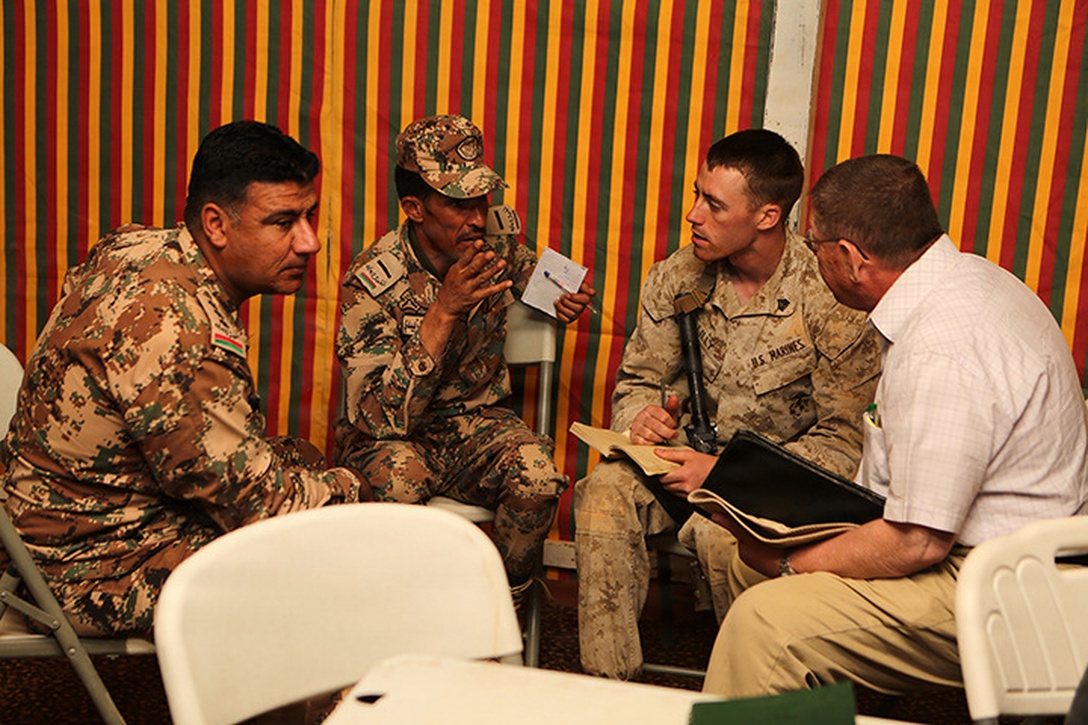 Sergeant Phillip Lilly, a scout sniper with Lima Company, Battalion Landing Team 3rd Battalion, 6th Marine Regiment, 24th Marine Expeditionary Unit, discusses exercise plans with Jordanian service members in preparation for Exercise Eager Lion 2015 in Jordan, May 3, 2015. Eager Lion is a recurring multinational exercise designed to strengthen military-to-military relationships, increase interoperability between partner nations, and enhance regional security and stability. The 24th MEU is embarked on the ships of the Iwo Jima Amphibious Ready Group and deployed to maintain regional security in the U.S. 5th Fleet area of operations. (U.S. Marine Corps photo by Sgt. Devin Nichols/Released)