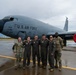 Six U.S. Air Force personnel pose together on a wet tarmac in front of a KC-135 Stratotanker aircraft marked with tail number 0331, assigned to the 6th Air Refueling Wing (6 ARW) and 927th Air Refueling Wing (927 ARW). The group consists of a mix of flight crew members in olive/sage green flight suits and support personnel in OCP (Operational Camouflage Pattern) uniforms. The overcast, rainy conditions suggest a post-mission or deployment photo opportunity.