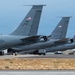 The image shows multiple U.S. Air Force AMC (Air Mobility Command) aircraft parked on a flight line, viewed from the rear showing their tail sections. At least two tail numbers are visible: 71437 and 38887, consistent with KC-135 Stratotanker aircraft. The aircraft are painted in standard gray military livery and display American flags on their vertical stabilizers.