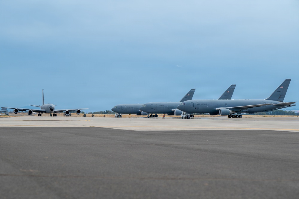 Multiple U.S. Air Force military aircraft are parked on a flight line ramp at what appears to be a military airfield. The aircraft are painted in standard gray livery and display 'U.S. AIR FORCE' markings. The scene depicts a static ground operation with overcast sky conditions.