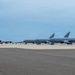 Multiple U.S. Air Force military aircraft are parked on a flight line ramp at what appears to be a military airfield. The aircraft are painted in standard gray livery and display 'U.S. AIR FORCE' markings. The scene depicts a static ground operation with overcast sky conditions.