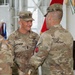 Two U.S. Army soldiers in OCP (Operational Camouflage Pattern) uniforms are engaged in what appears to be a military ceremony, likely a change of responsibility or assumption of command. The soldier facing the camera, identified by name tape as 'LAROCQUE,' holds a guidon staff and wears Command Sergeant Major rank insignia. The soldier with his back to the camera is identified by name tape as 'HARRINGTON' and both wear the 7th Army patch on their left shoulders.