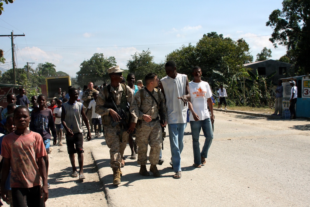 Capt. Gabe Diana, Battalion Landing Team, 1st Battalion, 9th Marine Regiment, 24th MEU, talks with a Mirebalais, Haiti local as he is guided to the local hospital.  Diana was the team leader for the 10-man team who inserted in the town via MV-22 Osprey to assess if the recent earthquake caused any damage or need for immediate relief.