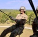 Two U.S. Army soldiers are conducting a rappelling exercise from what appears to be a helicopter or elevated platform. The soldier in the foreground, wearing helmet number 321 with the last name 'VERDONE' visible, is actively rappelling while gripping a rope. A second soldier with helmet number 408 and name tag 'ALJAWARE' observes from inside the aircraft.