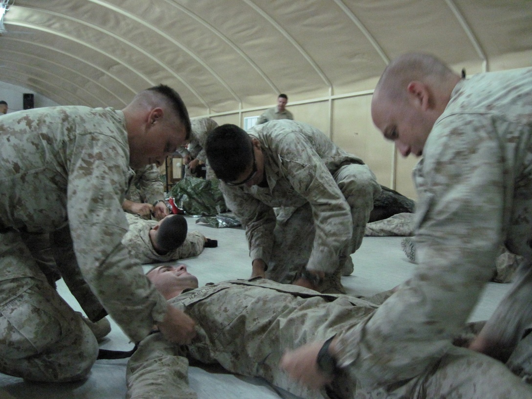 Marines attached to Combine Anti-Armor Team Platoon, Team 2, Battalion Landing Team 1st Battalion, 9th Marine Regiment, 24th Marine Expeditionary Unit,  get some hands-on training with how to properly apply a tourniquet during a Tactical Combat Casualty Care class May 16.