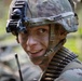 A soldier wearing MultiCam/OCP pattern camouflage gear is photographed in a close-up portrait. The soldier has face paint applied, wears a helmet with a night vision device mount, and carries a belt of ammunition across their chest. The name tape on the helmet reads 'WEBER'.