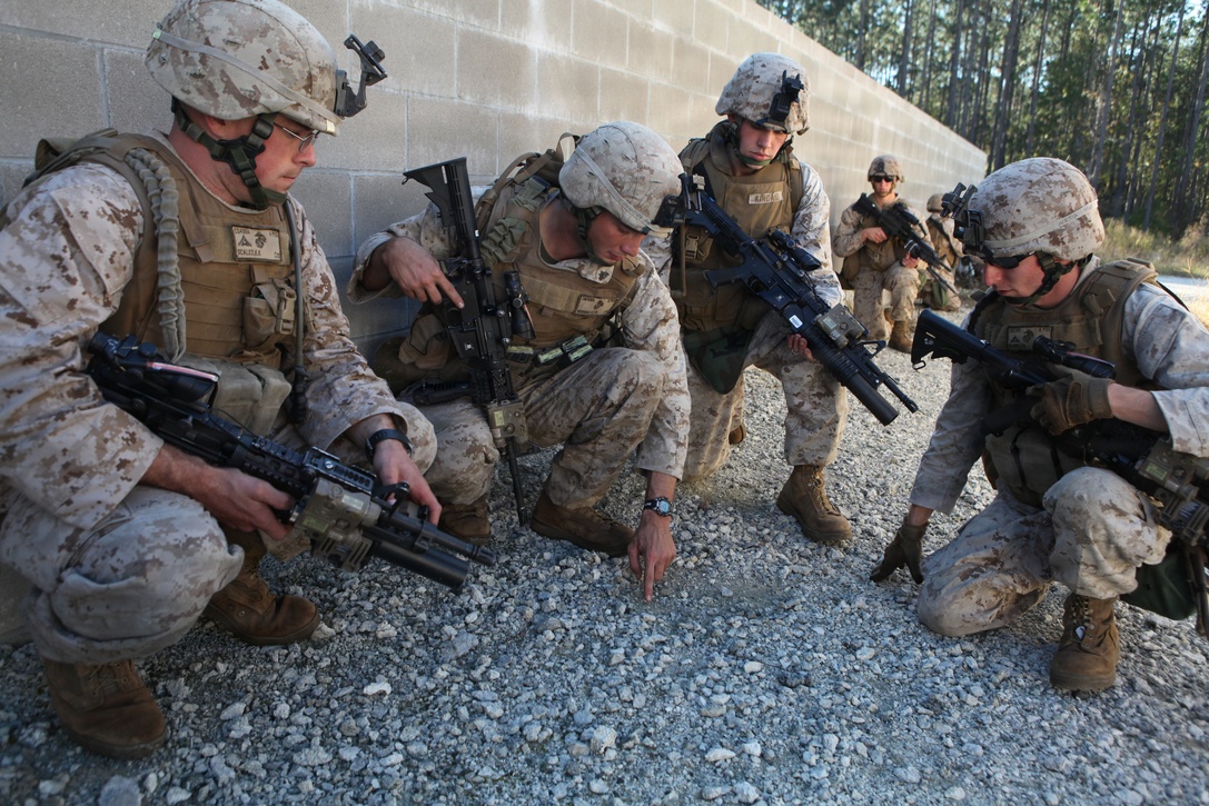 (From left to right) Lance Cpl. Kyle Scales, Cpl. Charles McDonald,  Cpl. Darrell Kincaid and Lance Cpl. Jonathan Black, Marines with Charlie Company, 1st Battalion, 2nd Marine Regiment, plan how they will move their squad through an open area while patrolling during the Motorized Raid Course Oct. 25, at Stone Bay's Home Station Lane Training complex here. The course took place Oct. 24 to Nov. 4 to prepare the company to serve as the 24th Marine Expeditionary Unit's motorized raid force.