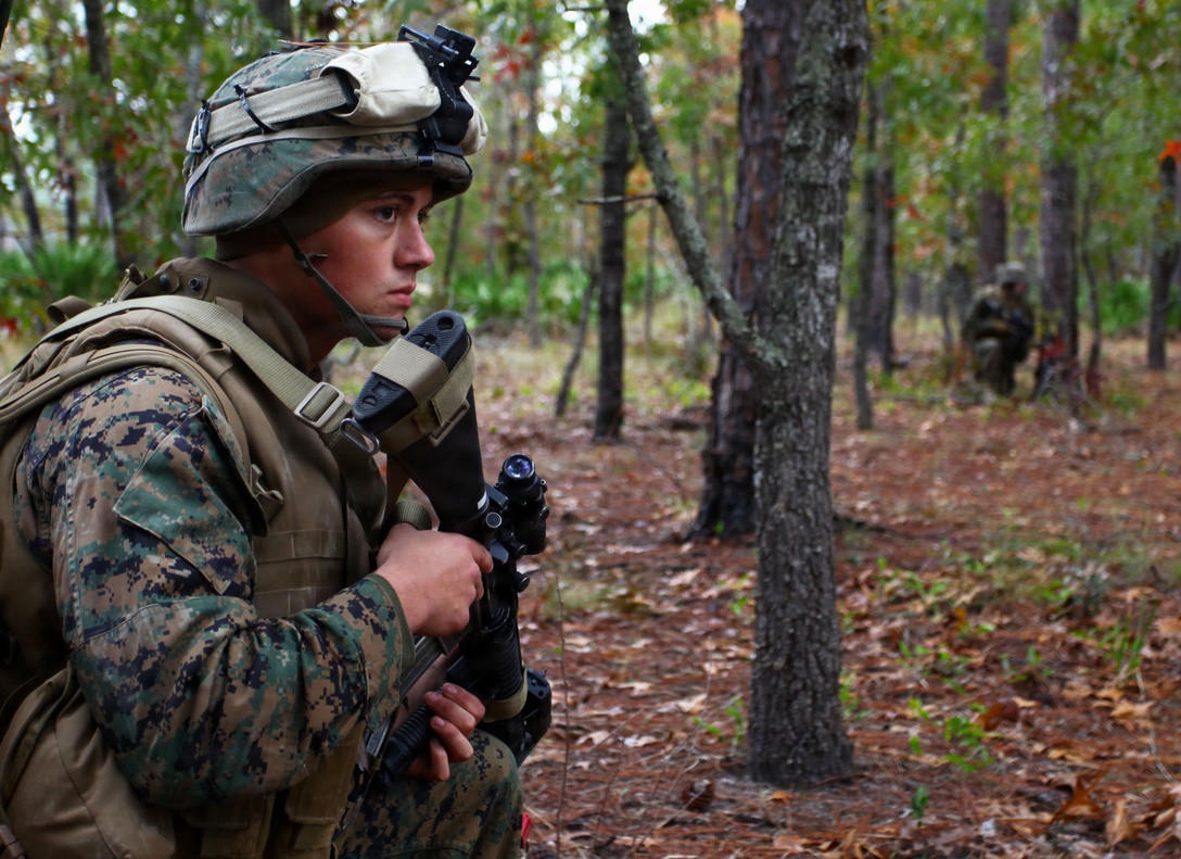 Lance Cpl. Mitchell Montgomery, a radio operator with Bravo Company, Battalion Landing Team 1st Battalion, 2nd Marine Regiment, 24th Marine Expeditionary Unit, takes a knee and keeps watch as his unit secures an airfield to set up an aid distribution site during a simulated humanitarian assistance operation here Dec. 10, 2011. Supporting humanitarian assistance and disaster relief missions is a task that MEUs train for during their six-month work up period to prepare for deployment. The 24th MEU is currently taking part in Composite Training Unit Exercise (COMPTUEX), scheduled to take place Nov. 28 to Dec. 21. The training is meant to develop cohesion between the 24th MEU and Amphibious Squadron 8 (PHIBRON 8) in conducting amphibious operations, crisis response, and limited contingency operations while operating from the sea.