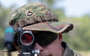 U.S. Army Pfc. Gabriel Joy aims down the sights of his M249