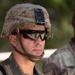 A U.S. Army soldier is photographed in close-up wearing Operational Camouflage Pattern (OCP) uniform and helmet with tactical eyewear. The soldier's name tape reads 'GAN' (partially visible) and rank insignia indicates Staff Sergeant (SSG). The helmet bears the identifier 'DAM7396' and has a night-vision mount bracket attached to the front.