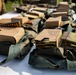 The image shows multiple military ammunition pouches and cardboard boxes laid out on a white table. The boxes are labeled '5.56MM Ball M855 10 RD Clips' and contain stripper clips loaded with 5.56×45mm NATO cartridges. This appears to be an ammunition distribution or pre-range preparation setup in a military or training environment.