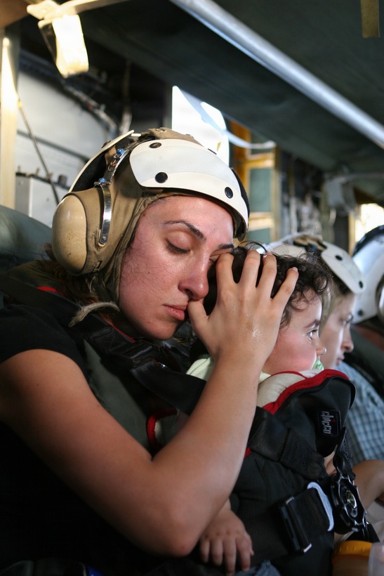Cyprus ? A U.S. citizen calms a child July 18 while traveling in a CH-53 Super Stallion helicopter to Cyprus following their departure from the U.S. Embassy in Beirut, Lebanon.