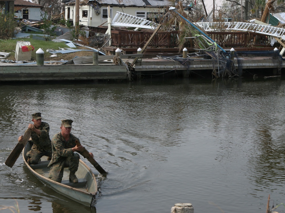 ST. BERNARD PARISH, La. (Sep. 10, 2005) -Using a 'Jim boat' pulled from a tree and make shift paddles, Cpl. Kyle E. Gaubert and Lance Cpl. Brandon K. Burleigh, riflemen with 1st Platoon, Bravo Company, 1/8, cross a small canal in order to search homes unreachable from any other way. The Marines of Bravo's 1st Platoon were the first on the ground to search the remote community in St. Bernard Parish.
