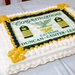A large rectangular sheet cake celebrating a military promotion ceremony for three individuals being promoted to the rank of Captain. The cake features Navy Captain insignia including eagle devices, rank stripes, and anchor decorations in navy blue and gold frosting. The names Duncan, Gunter, and Lease are displayed prominently on the cake's fondant topper.