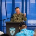 A U.S. Navy officer with the name tag 'ZERR' and a single star insignia (Rear Admiral Lower Half/Brigadier General equivalent) is speaking at a podium bearing the Surface Navy Association logo. The officer is wearing Navy Working Uniform (NWU) digital camouflage and is gesturing with one hand while addressing an audience. The event appears to be a Surface Navy Association gathering or symposium.