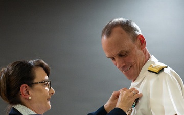 Ms Elizabeth Nashhold Pins the Legion of Merit star onto Rear Admiral Scott Brown