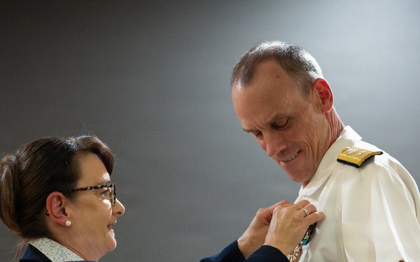Ms Elizabeth Nashhold Pins the Legion of Merit star onto Rear Admiral Scott Brown