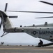 A U.S. Marines heavy-lift helicopter, identified as bureau number 164783 and assigned to HMH-WEST, is positioned on what appears to be the flight deck of a naval vessel. The helicopter's rotors are in motion, visible as motion blur in the frame. A crew member in flight gear is visible crouching near the rear of the aircraft.