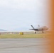Two F-35 stealth fighter jets are visible on an airfield taxiway or apron, with one in the foreground and one in the background. Airfield signage including an 'ILS' marker (red) and a taxiway 'G B' directional sign (yellow) are clearly visible. The right portion of the image is obscured by an orange blur, likely caused by a nearby aircraft or object partially entering the camera frame.