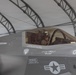 A military pilot is seated in the cockpit of an F-35 Lightning II fighter jet, parked inside a temporary fabric hangar structure. The aircraft bears the name 'LT C.S. O'REILLY' with the callsign 'SPLASH' and the aircraft number '06', along with standard U.S. military markings. The pilot is wearing a full flight helmet and appears to be conducting pre-flight or post-flight procedures.