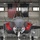 104th Fighter Wing hosts Springfield Chamber of Commerce Breakfast A front-facing view of an F-35 Lightning II stealth fighter jet parked inside a military hangar. The aircraft has its weapon bay doors open, revealing red safety covers and 'Remove Before Flight' tags. An American flag and a black 'WEAPONS' banner are prominently displayed on the hangar wall behind the aircraft.