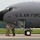 104th Fighter Wing Celebrates Flight Surgeon's Fifteen Years of Service with Fini Flight A U.S. Air Force military aircraft, identified by the serial number 0332, is parked on a tarmac. Three ground crew members in military uniforms are standing near the nose landing gear, appearing to communicate with each other. A pilot or crew member is visible in the cockpit window above.