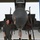 104th Fighter Wing Celebrates Flight Surgeon's Fifteen Years of Service with Fini Flight A smiling male aviator in an olive/gray flight suit stands at the nose of a military jet aircraft inside a hangar. He is posing with one hand resting on the large radome (nose cone) of what appears to be an F-15 Eagle. The aircraft is on chocks with safety streamers and ground equipment visible.