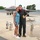 104th Fighter Wing Celebrates Flight Surgeon's Fifteen Years of Service with Fini Flight A military pilot in a flight suit poses with a woman on an aircraft tarmac in front of an F-35 fighter jet. The pilot has his arm around the woman and is holding a Monster Energy drink. The setting appears to be a military air base, likely during a post-flight celebration or reunion.