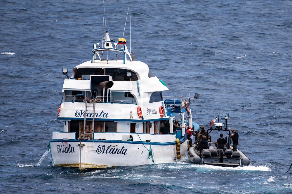 A law enforcement or military interdiction operation is underway at sea, with a rigid inflatable boat (RIB) carrying armed personnel alongside a larger white vessel named 'Manta'. The larger vessel displays what appears to be an Ecuadorian flag and registration markings. Personnel in tactical gear are visible transferring or boarding between the two vessels.
