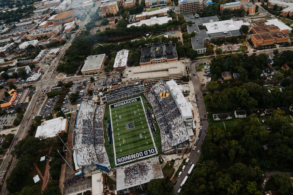 An aerial photograph of S.B. Ballard Stadium, home of the Old Dominion University Monarchs football team, located in Norfolk, Virginia. The stadium is partially filled with spectators during what appears to be a game day event, surrounded by the urban campus and residential neighborhoods. The field displays 'MONARCHS' and 'OLD DOMINION' branding clearly visible from above.