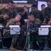 A joint military exercise or command post operation involving U.S. Army and Japanese Ground Self-Defense Force (JGSDF) personnel gathered around workstations. Name placards identify 'Fires Director COL Wheatley' and 'AFSCOORD LTC Koma,' indicating a combined fires coordination exercise. Personnel are closely examining equipment and documents at a command operations center setup.