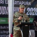 A U.S. Army officer with the name tag 'MATTHAIDESS' and a single star insignia (Brigadier General rank) is speaking at a podium during the 'Garuda Shield 2026' military exercise event. The event appears to be held in Indonesia, indicated by the banner referencing 'Amerika' and the Indonesian text. A civilian in traditional Indonesian attire stands to the right holding a red folder.