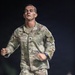A U.S. Army soldier wearing OCP (Operational Camouflage Pattern) uniform is running at night on what appears to be a dirt path or track. The soldier's name tape reads 'CLAY' and the branch tape reads 'U.S. ARMY,' with a unit patch visible on the left shoulder. The image captures an apparent physical fitness test or training run, with the soldier showing visible exertion.