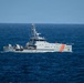 A Venezuelan Coast Guard patrol vessel designated LG-30 is underway on open ocean waters. The gray-hulled ship bears the name 'GUARDACOSTAS' on its hull along with distinctive orange diagonal stripes, and flies what appears to be a Venezuelan flag from its mast. The vessel appears to be on active patrol duty in moderately choppy blue seas.