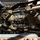 Military personnel in MultiCam/OCP camouflage uniforms are conducting a physical training or obstacle course exercise, climbing over or traversing a structure from an overhead perspective. At least one individual has a visible 'TACP' (Tactical Air Control Party) patch, identifying them as U.S. Air Force special operations personnel. The image is taken from directly above, creating a dynamic top-down composition.
