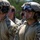 TACP Airmen master vertical infiltration The image shows a group of military personnel in tactical gear standing in formation, likely during a training exercise or briefing. They are wearing multicam/OCP camouflage uniforms, tactical helmets with mounted accessories, and ballistic eyewear. The soldiers appear attentive and focused, suggesting they are receiving instructions or awaiting orders.